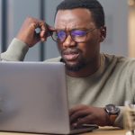 Black man confused looking at computer